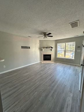 Jacksonville house for rent - A living room with a fireplace and a ceiling fan.