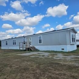 Shawnee house for rent - A grey house with a wooden deck and stairs leading to the front door.