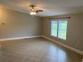 Concord house for rent - a empty living room with a ceiling fan and a window