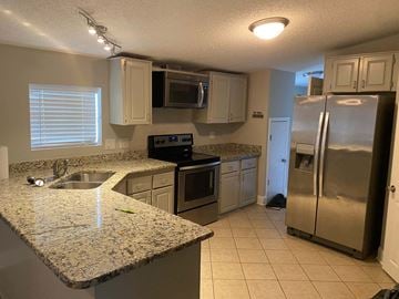 Concord house for rent - a kitchen with stainless steel appliances and granite counter tops