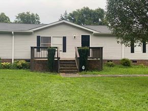Concord house for rent - a white mobile home with a porch and a yard