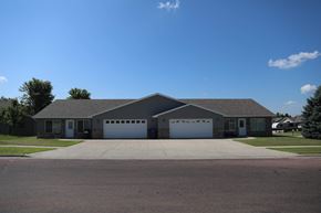 Dell Rapids apartment for rent - a large house with a driveway and garage doors