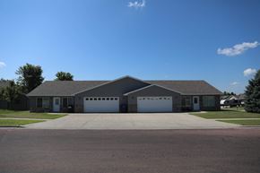 Dell Rapids apartment for rent - a large house with a driveway and garage doors