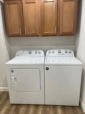 Lima apartment for rent - A pair of white front loading washing machines in a laundry room.
