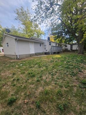 St. Louis house for rent - A house with a grey roof and a white garage door is surrounded by trees.