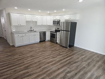 Lima apartment for rent - a kitchen with white cabinets and a stainless steel refrigerator