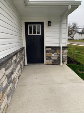 Lima apartment for rent - the front porch of a house with a concrete walkway and a black door