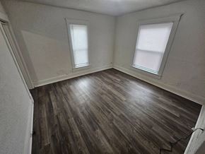 Lima house for rent - A room with wooden flooring and two windows.