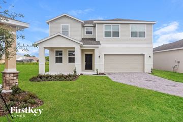 Kissimmee house for rent - a white house with a lawn in front of it