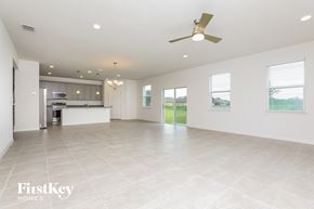 Kissimmee house for rent - an empty living room and kitchen with a ceiling fan