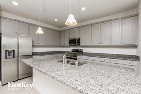 Kissimmee house for rent - a white kitchen with granite counter tops and white cabinets