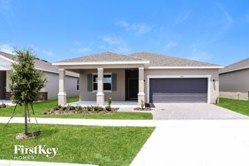 Kissimmee house for rent - a house with a driveway and a garage door