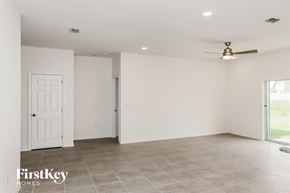 Kissimmee house for rent - an empty living room with white walls and a ceiling fan