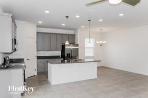 Kissimmee house for rent - a white kitchen with a large island and stainless steel appliances