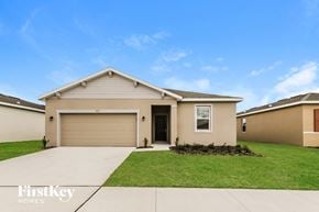 Bartow house for rent - a beige house with a lawn and a garage door
