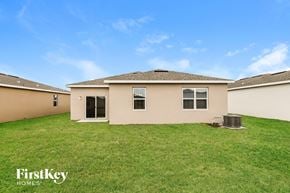 Bartow house for rent - a beige house with a grassy yard and a blue sky