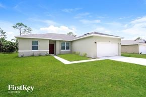 Palm Bay house for rent - A house with a red door and a white garage door is for sale.
