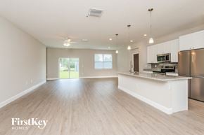 Palm Bay house for rent - A spacious kitchen and living room with wooden floors and white walls.