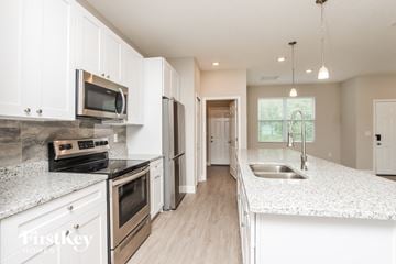 Palm Bay house for rent - A kitchen with white cabinets and a granite countertop.