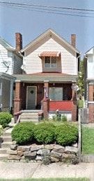 Clairton house for rent - A house with a red door and a brick chimney.