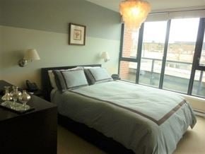 Vancouver apartment for rent - a bedroom with a bed and a large window