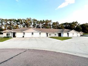 Dell Rapids apartment for rent - A large building with a parking lot in front of it.