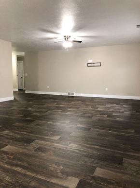 Dell Rapids apartment for rent - A room with a wooden floor and a ceiling fan.