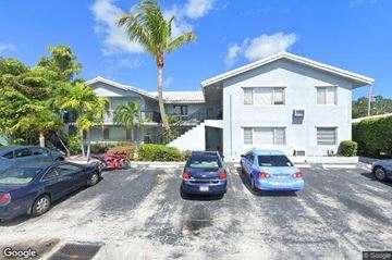 Fort Lauderdale apartment for rent - A white house with a blue car parked in front.