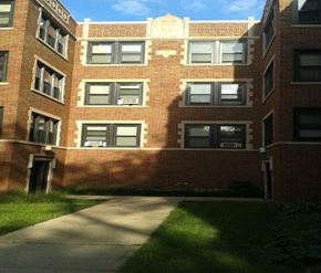 Chicago apartment for rent - a tall brick building with a sidewalk in front of it