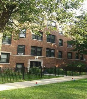 Chicago apartment for rent - a brick building with a black fence in front of it
