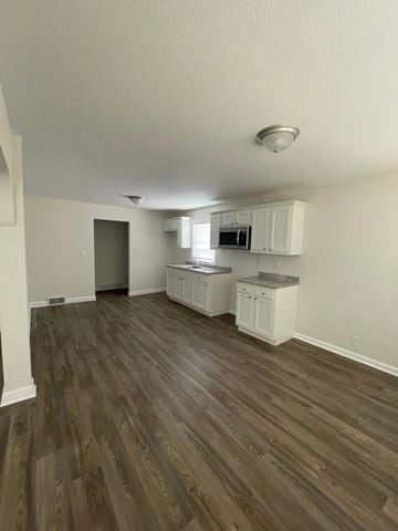 Lima house for rent - A kitchen with white cabinets and a microwave.