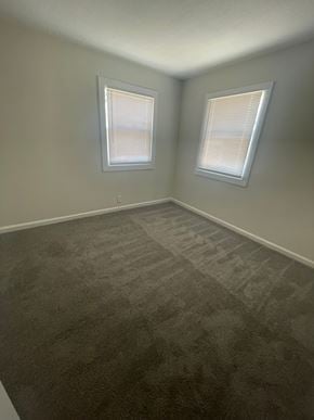 Lima house for rent - A room with grey carpet and two windows.