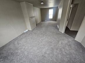 Lima house for rent - A long, empty hallway with carpeted floors and white walls.