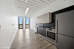 Chicago apartment for rent - a kitchen with stainless steel appliances and black and white cabinets