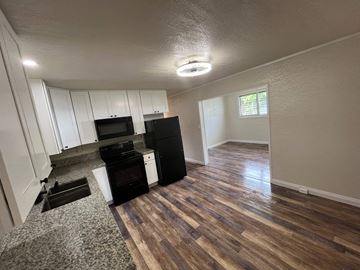 Hilo apartment for rent - an open living room with a kitchen with a stove and refrigerator