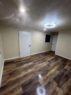 Hilo apartment for rent - a empty living room with wood flooring and white walls