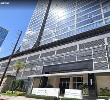 Honolulu apartment for rent - A modern building with a sign that reads "PACIFICA" in front of it.