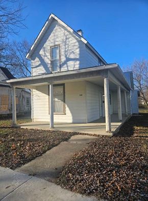 Lima house for rent - A small white house with a porch and a covered walkway.