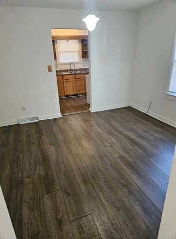 Lima house for rent - A room with wooden flooring and a kitchen visible through the door.