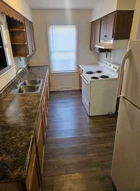 Lima house for rent - A kitchen with a white refrigerator, sink, and stove.