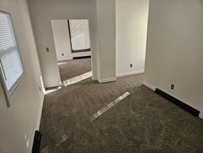Lima house for rent - A carpeted room with a white door and a window with blinds.