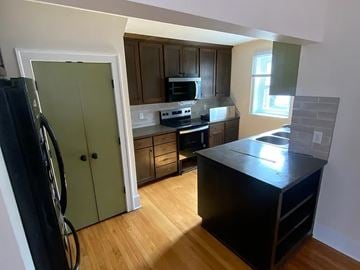Omaha apartment for rent - A kitchen with a black counter top and wooden floors.