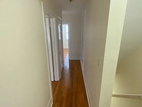 Omaha apartment for rent - A long hallway with wood floors and white walls.