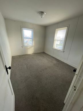 Lima house for rent - an empty room with a carpeted floor and two windows