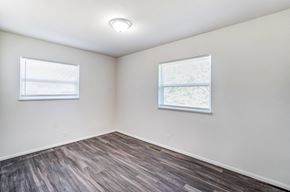 Lima apartment for rent - an empty room with wood flooring and two windows