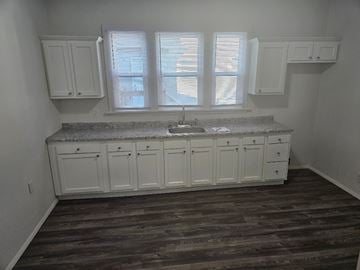 Lima house for rent - A kitchen with white cabinets and a granite countertop.