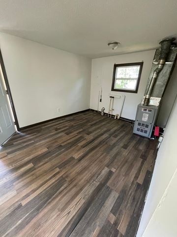 Lima house for rent - the living room has hardwood floors and a white wall and a window and a