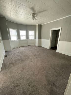 Cridersville apartment for rent - an empty living room with a ceiling fan and windows