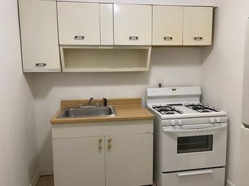 Louisville apartment for rent - A small kitchen with a white stove and a white sink.