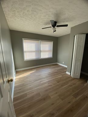 Shively apartment for rent - A room with a ceiling fan and wooden flooring.
